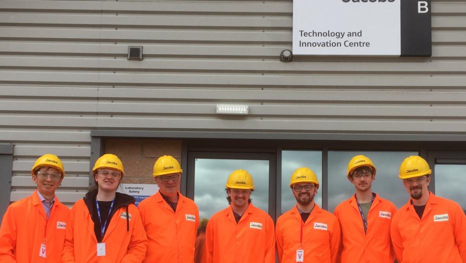 Team of engineers in orange PPE suit with yellow hard hats 