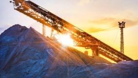 Stock image of a conveyor in sunset over a pile of sediment