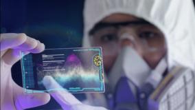 Researcher in full lab PPE looking at a virtual reality slide of data