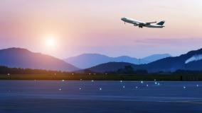 Airplane taking off in front of mountains