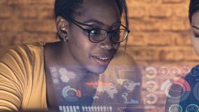 Black woman and mideast woman looking at a hologram of location based data