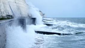 Sea spray and waves hitting coastal walkway