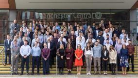 Group of our apprentices and graduates on steps in Manchester city center.