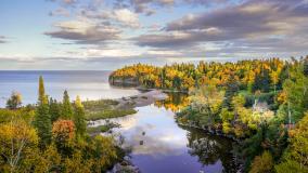 Beautiful reflections of clouds and Autumn colors on the Baptism River where it meets Lake Superior at Tettegouche State Park, Minnesota