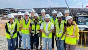 Jacobs interns in yellow PPE vests and white hardhats visit a project site