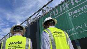 Koti Vadlamudi and Bob Pragada in yellow PPE vest and white hard hats look on to the Fujifilm Diosynth Biotechnologies facility unveiling