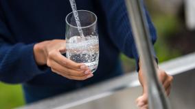 Woman's hands filling glass with water stock photo