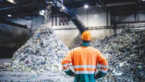 Person looking a pile of recycling