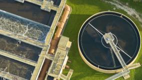 Aerial view of modern water cleaning facility at urban wastewater treatment plant. Purification process of removing undesirable chemicals, suspended solids and gases from contaminated liquid.