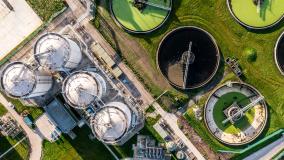 Aerial view above wastewater treatment plant with water storage tank