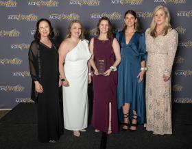 Five women in formal dress with their award at ACEC