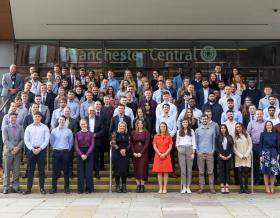 Group of our apprentices and graduates on steps in Manchester city center.