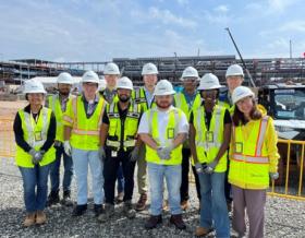 Jacobs interns in yellow PPE vests and white hardhats visit a project site