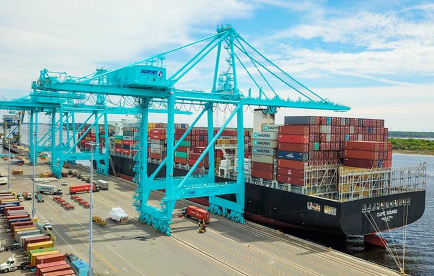 Container ship at a port with electric blue cranes