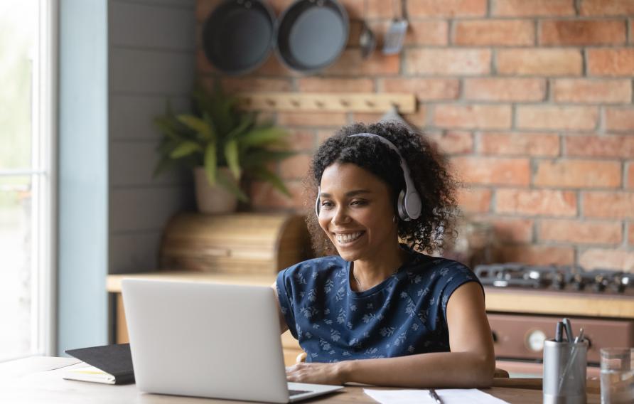 young female with headphones and laptop