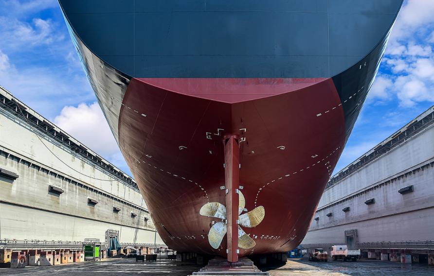 Underside of large ship with a fan at a dock