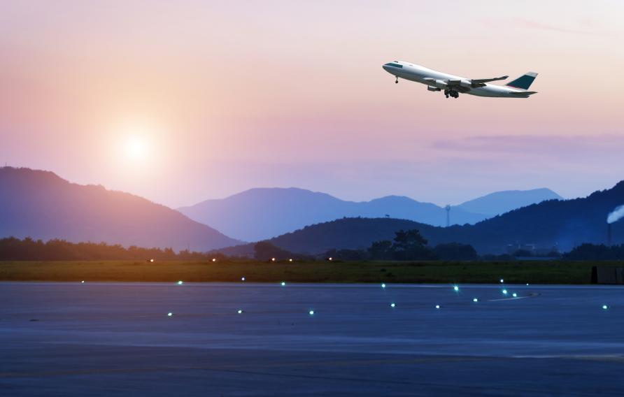 Airplane taking off in front of mountains