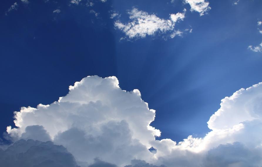 Clouds in front of sun and blue sky
