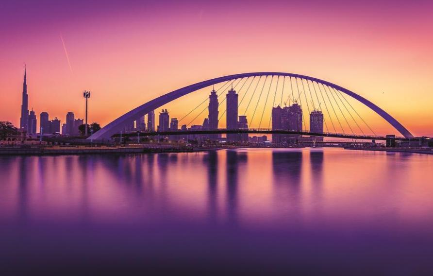 Dubai Water Canal - pink and purple hues with city scape and bridge