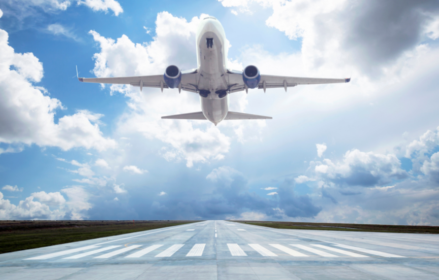 Airplane taking off on runway into blue skies