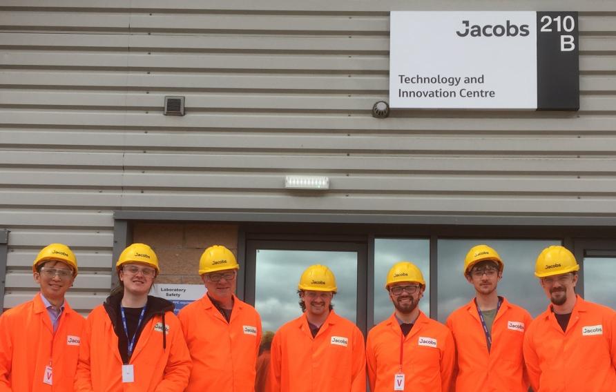 Team of engineers in orange PPE suit with yellow hard hats 