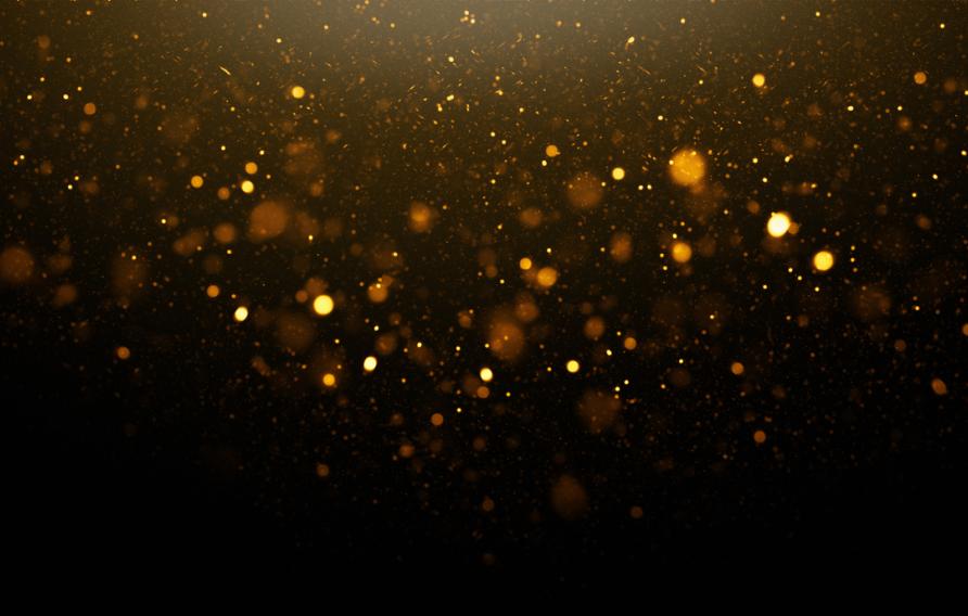 Gold confetti falls down in a dark room