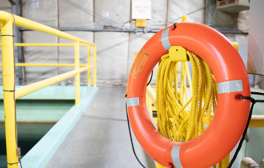 Orange life preserver hanging near a treatment pond