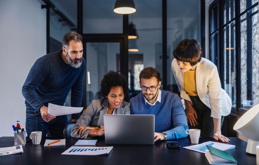 group of four people working and collaborating together in an office