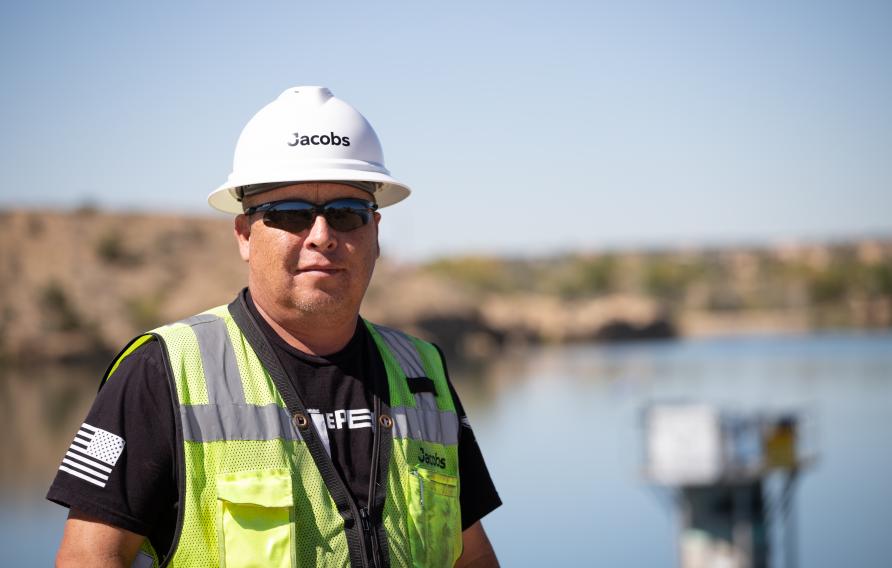 Man in white hard hart with Jacobs logo and yellow safety vest