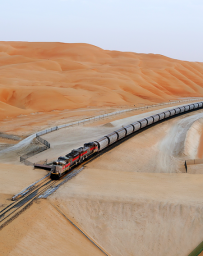 Etihad Rail - train driving between gorgeous orange sand dunes