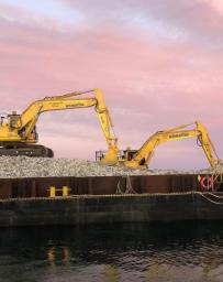 Two excavators at work on Windara Reef construction with pink sky at sunset behind them