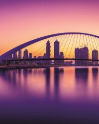 Dubai Water Canal - pink and purple hues with city scape and bridge