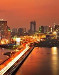 Aerial view of an orange-lit cityscape and rail lines 