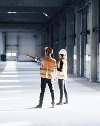 Stock image of two engineers in PPE in a stark facility