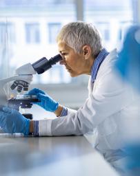 Chemist working on a microscope in laboratory