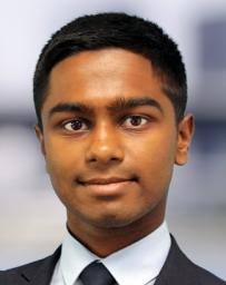 Headshot of man with dark hair in white shirt, dark grey tie and jacket