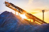 Stock image of a conveyor in sunset over a pile of sediment