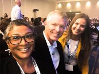 Tom price with two co-workers at the conference