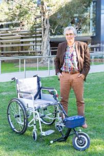 Hamid Torfeh Nejad with his invention that transforms a manual wheelchair into a motorized wheelchair quickly and easily