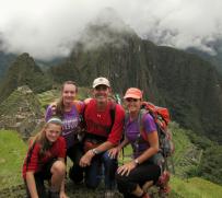Family of 4 standing near Machu Picchu