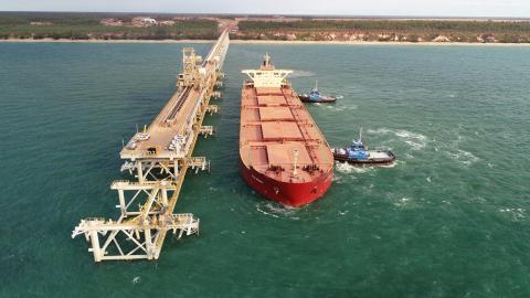 A red ship leaving the wharf at the new Amrun Chith export facility