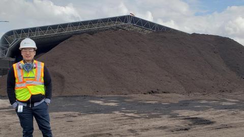 Engineer in front of waster material at Calgary composting facility