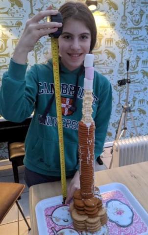 Young girl with cookie and marshmallow tower made in STEAM activity