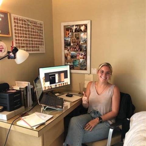 Female intern at computer with thumbs up