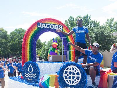 Jacobs float at Dallas Pride 2019 - rainbow archway and people standing on float