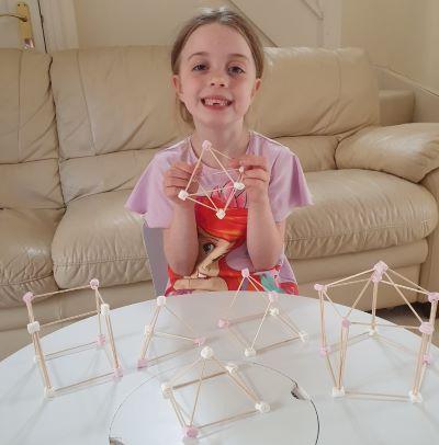 girl with 3D shapes made out of sticks and marshmallows for STEAM activity