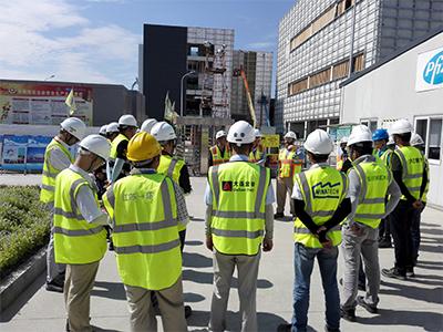 people in safety vests and hard hats outside pfizer facility china