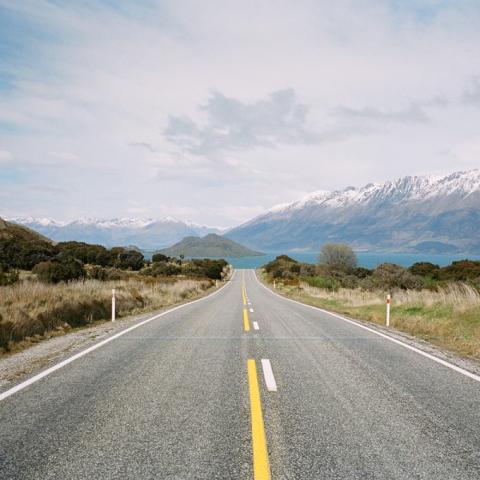 A road in New Zealand with mountains in the background