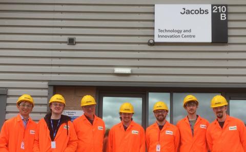 Team of engineers in orange PPE suit with yellow hard hats 