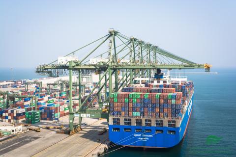 Container ship coming into a port with cranes overhead